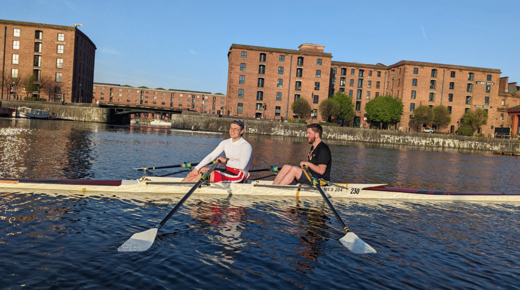 Two men in a double (2x) rowing in the day on Albert Dock
